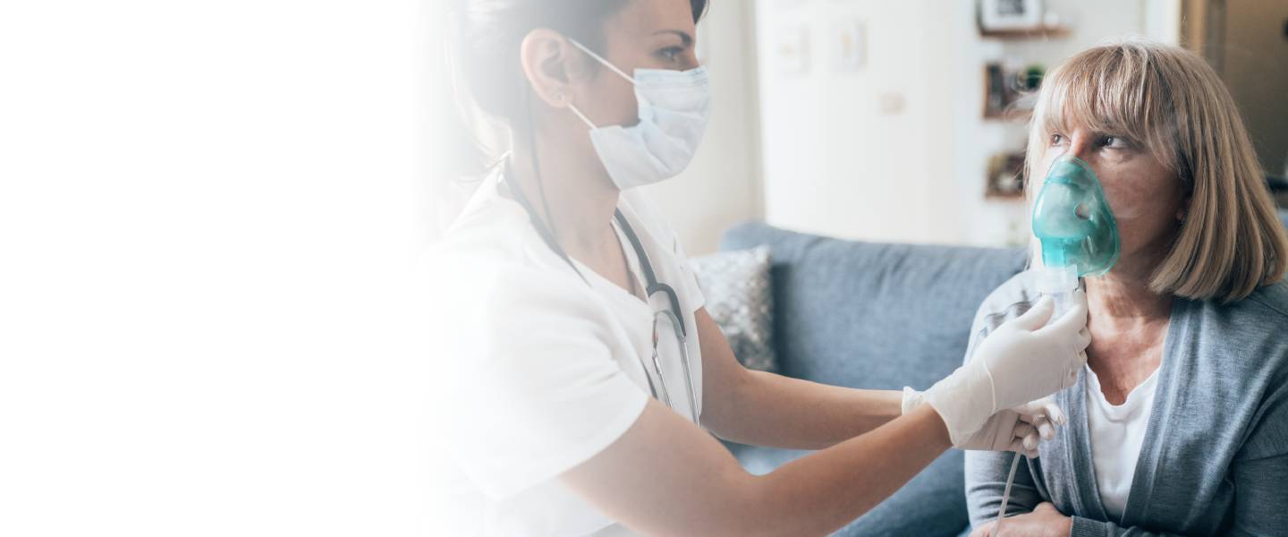 doctor assisting woman with breathing mask
