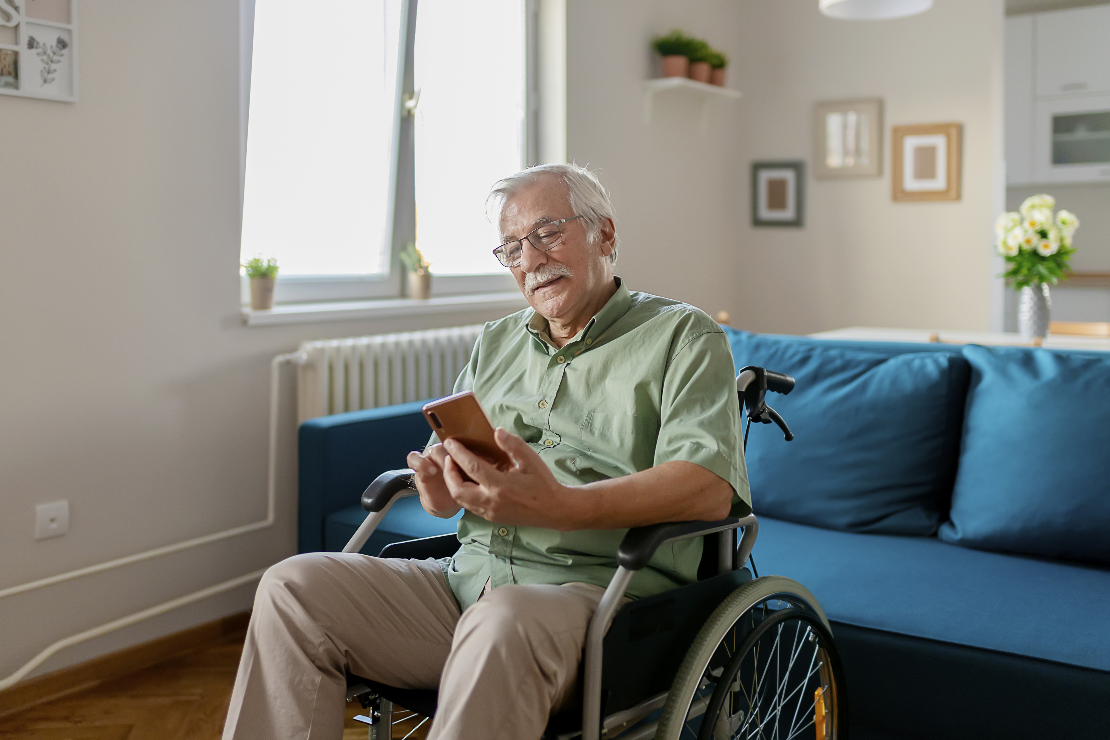 Older man in wheelchair on phone
