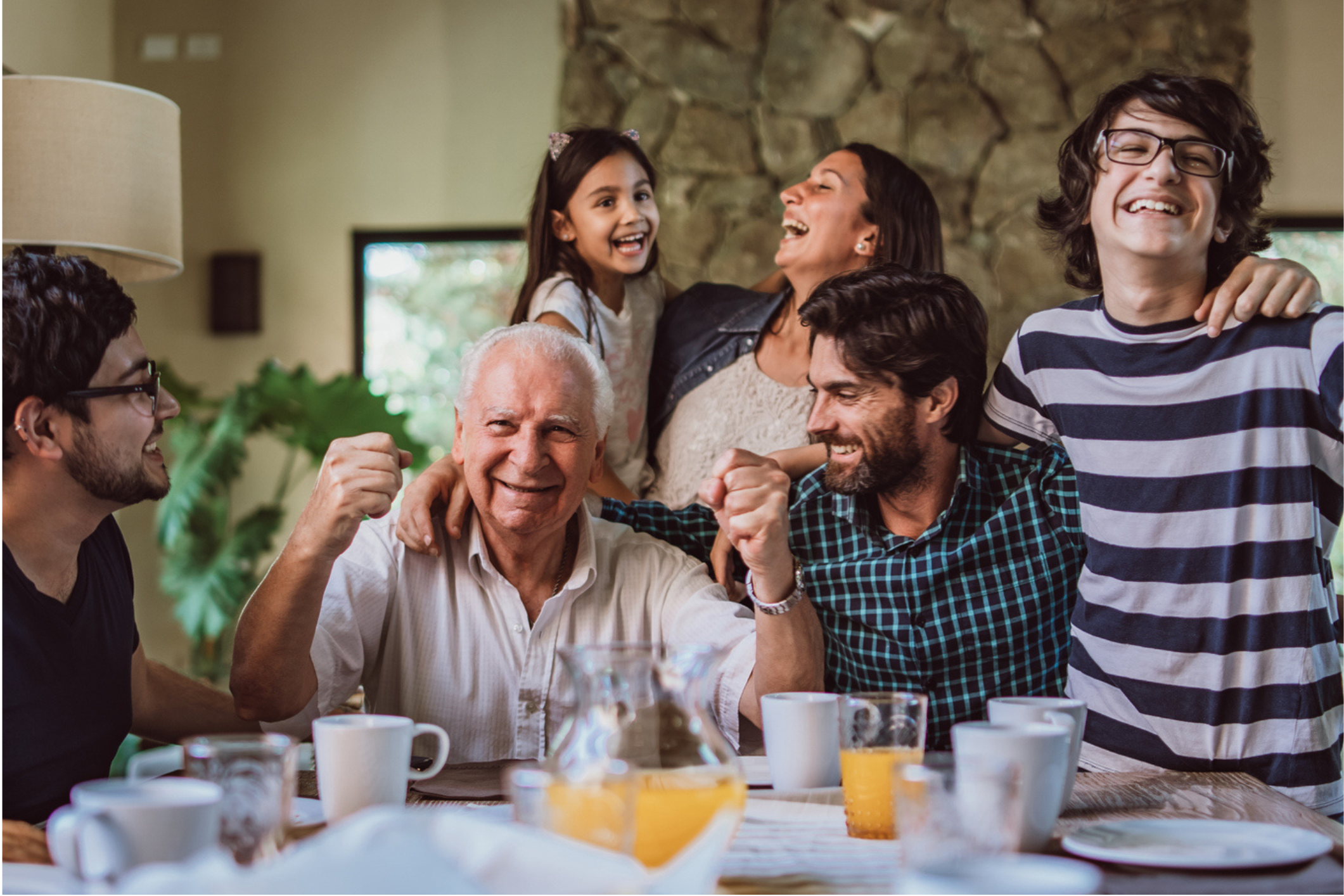 Man celebrating with family at the dinner table in his home.