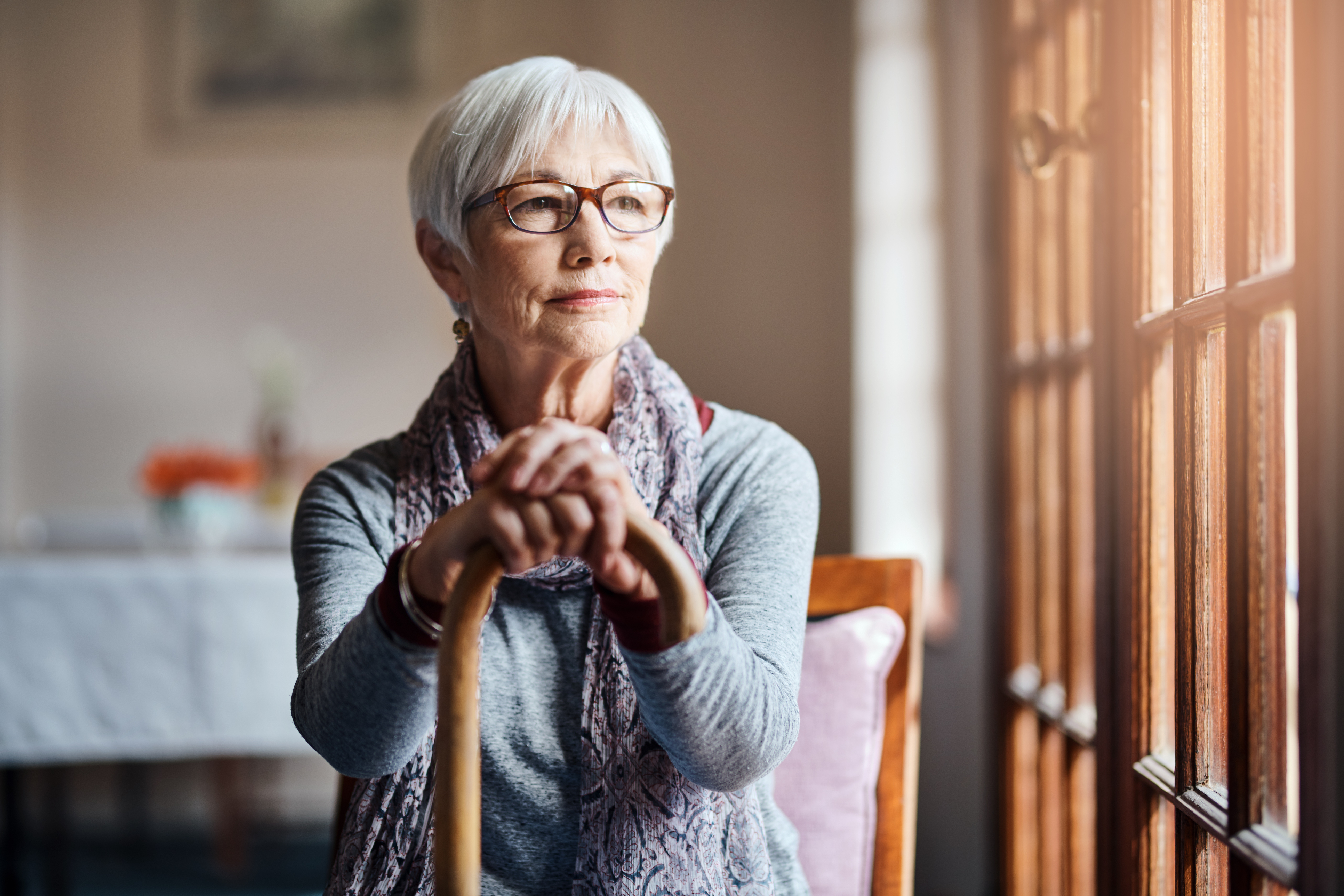 Older woman at home looking out window