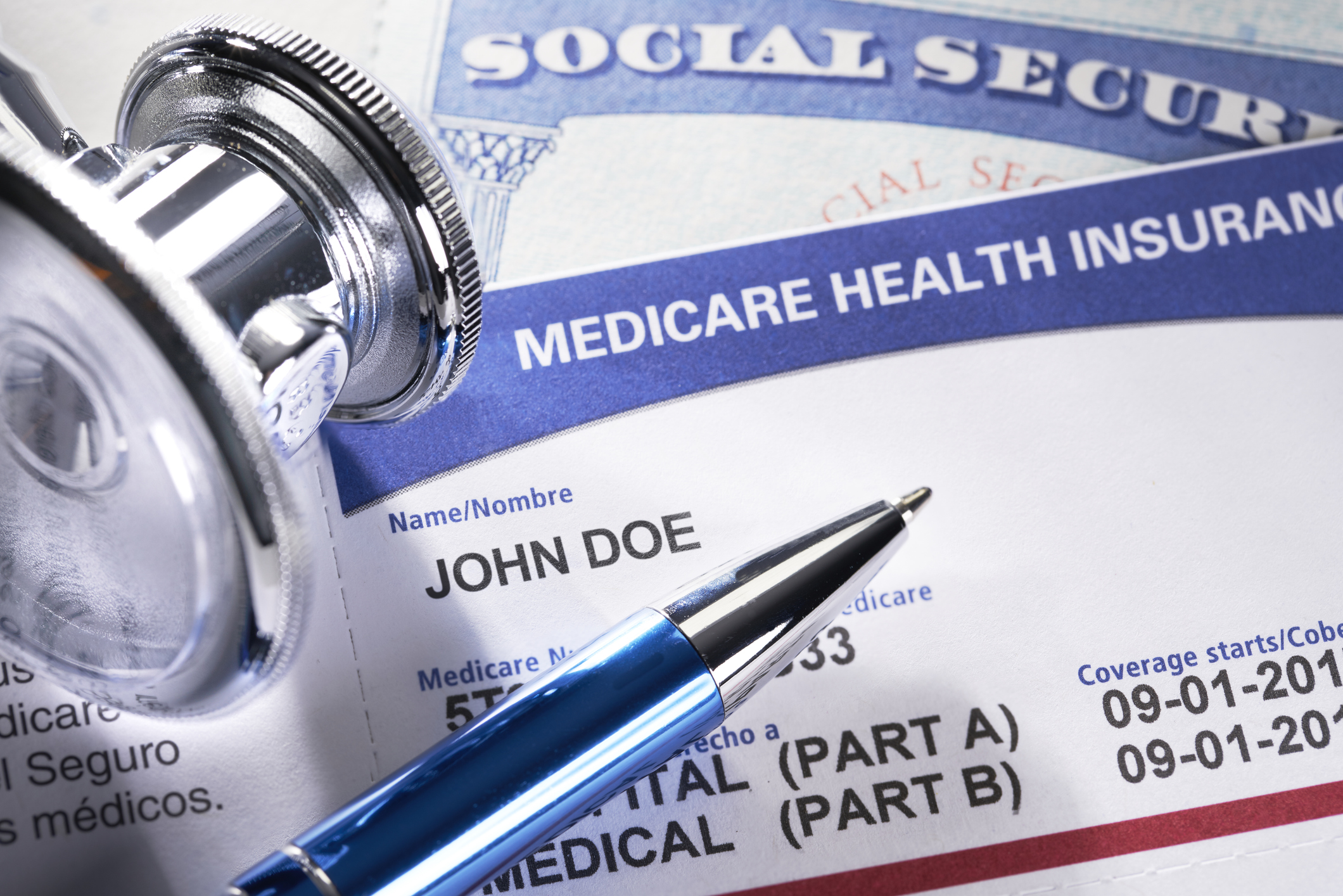 Closeup of a Medicare card, pen and stethoscope.